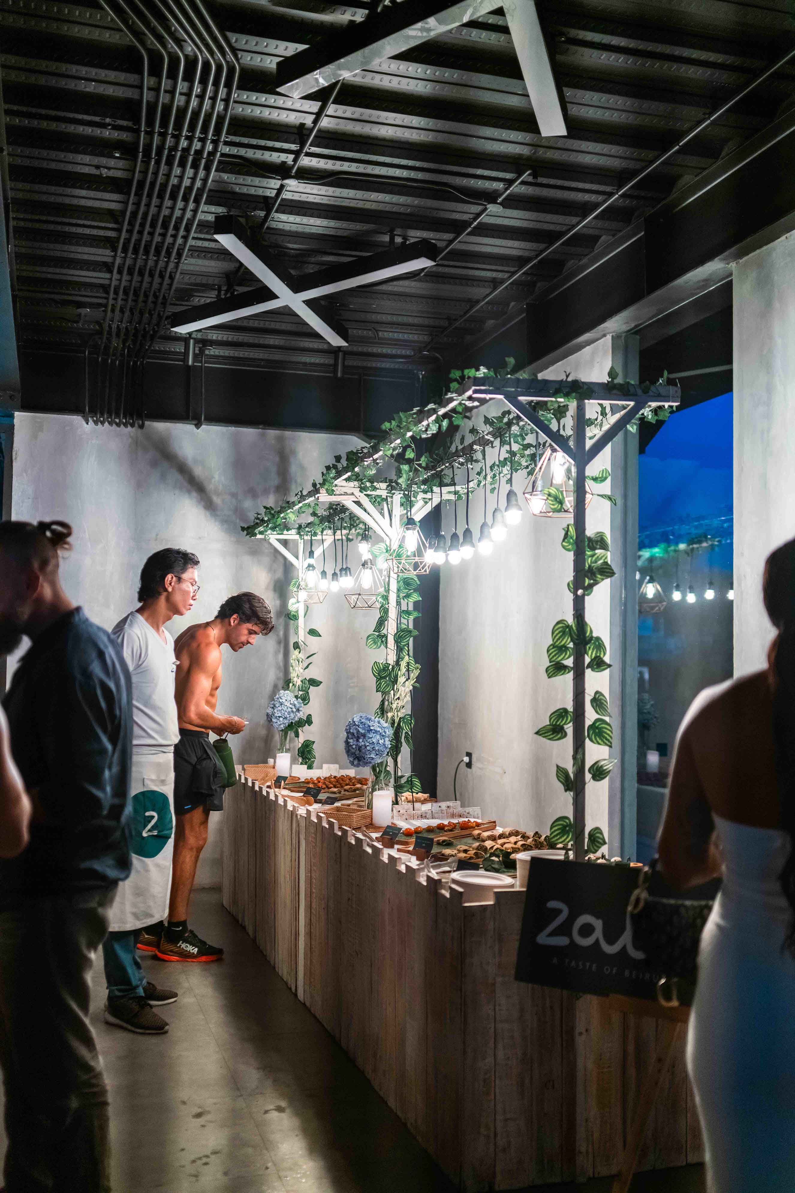 Guests enjoying a catered food display under decorative lights and greenery at the Wrong Night event hosted by Wrong Gym Bali.