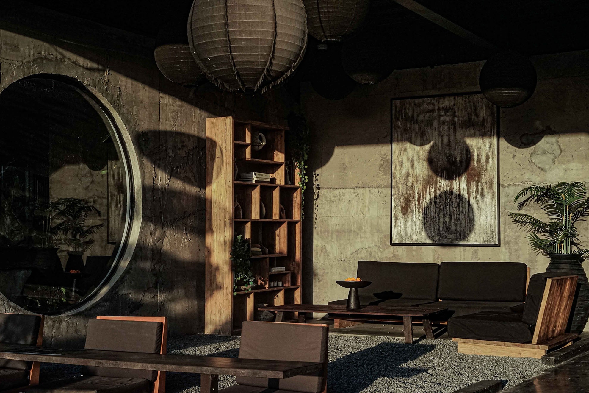 Warm-toned recovery lounge and cafe at Wrong Gym Bali, featuring minimalist wooden furniture, soft lighting, and contemporary decor with a modern industrial aesthetic.