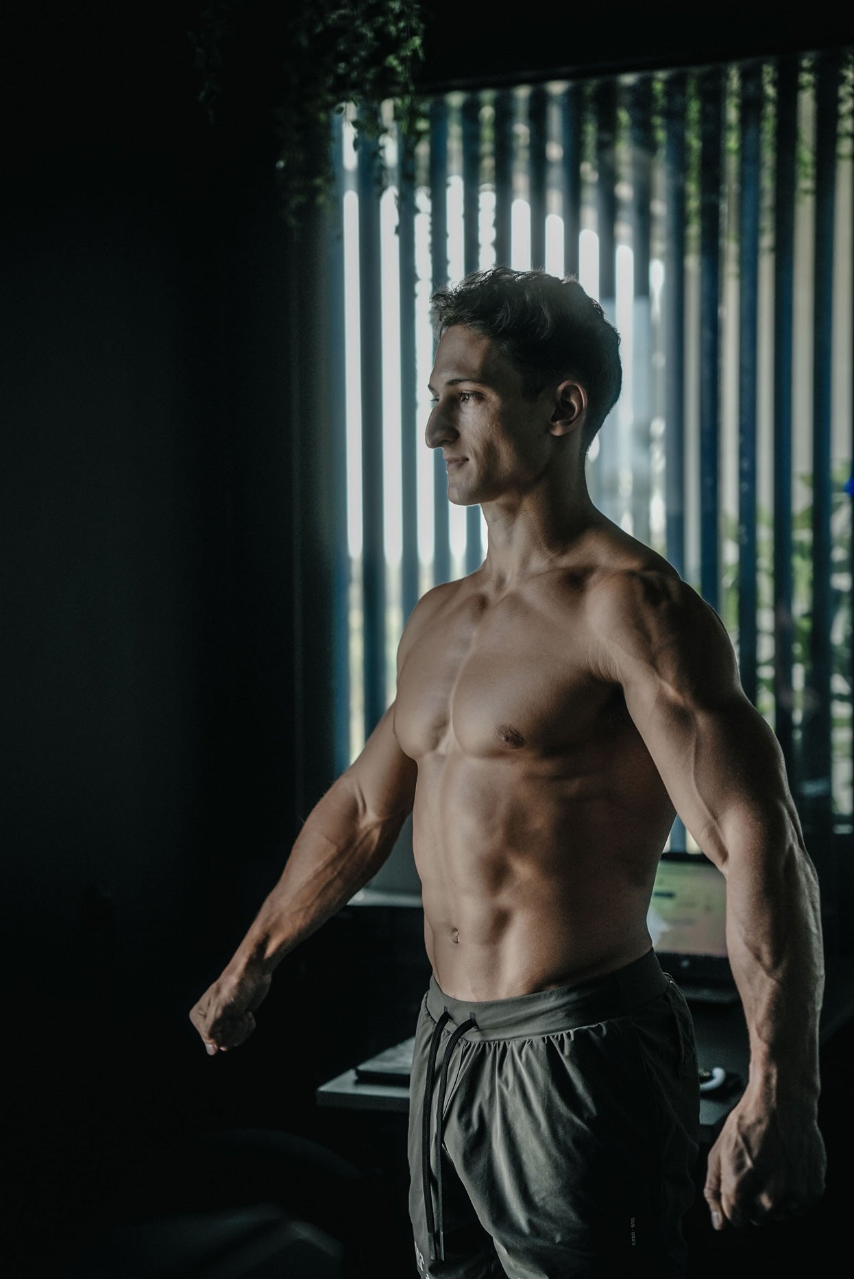 Fit male posing shirtless at The Lab by Wrong Gym Bali, showcasing muscular physique in a moody, neon-lit fitness environment.