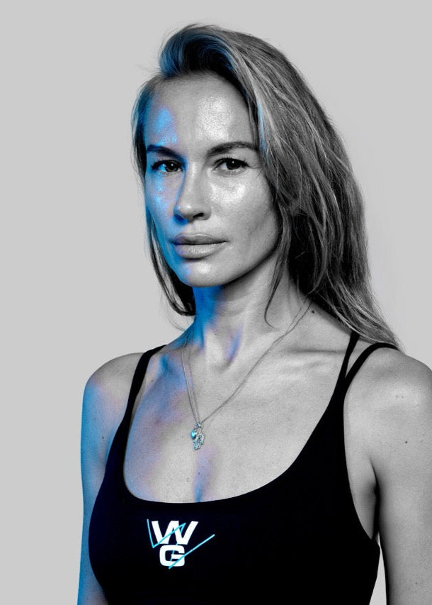 Confident portrait of Wrong Gym Bali trainer Linda in branded activewear, showcasing strength and poise.