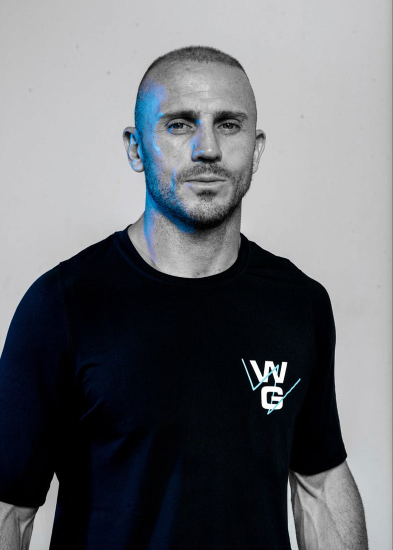 Portrait of Wrong Gym Bali trainer Paul wearing branded athletic wear, representing confidence and leadership.