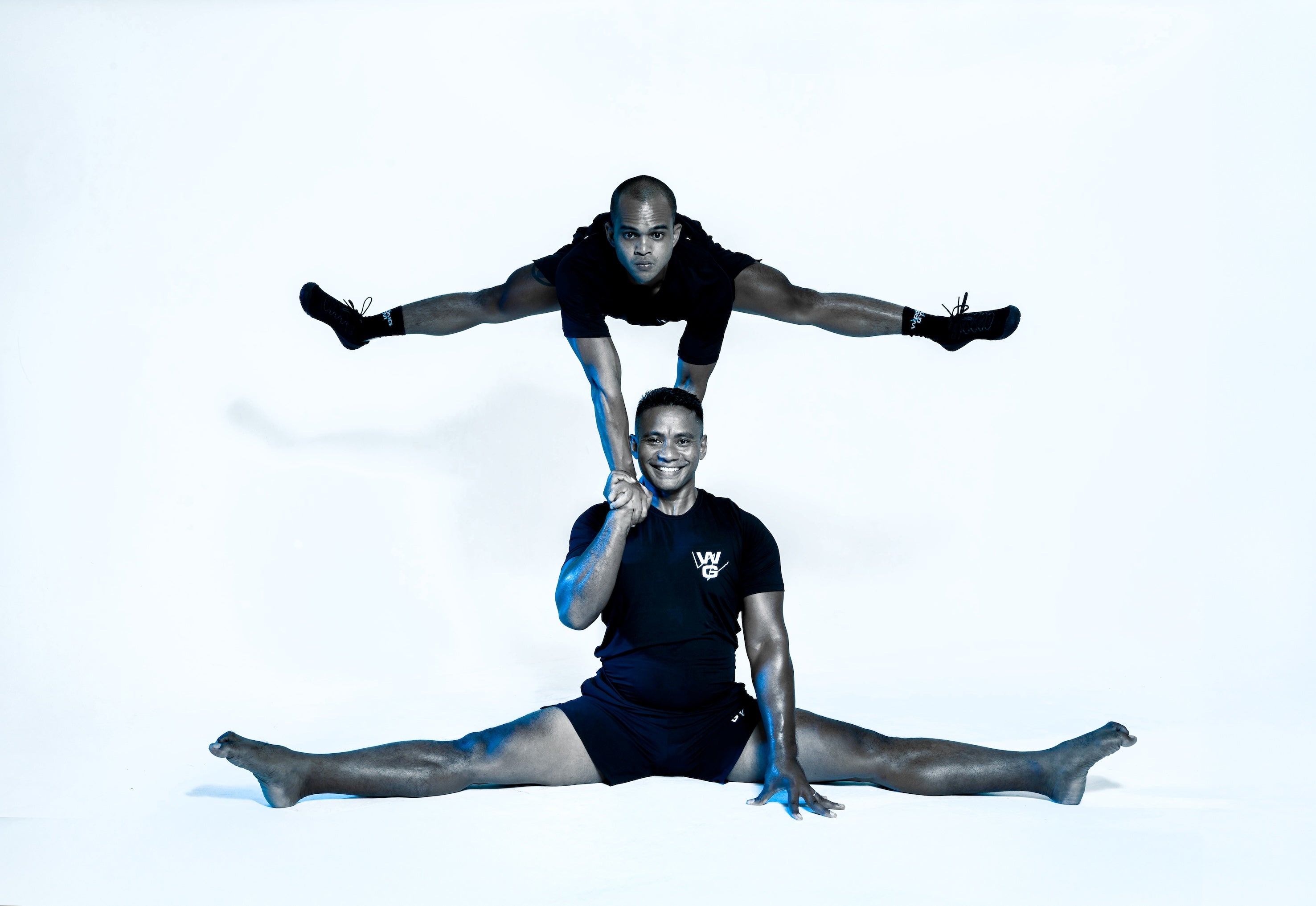Wrong Gym Bali mobility coaches Norman and Dedy demonstrate advanced acrobatic strength and flexibility with a split and elevated hand balance pose.