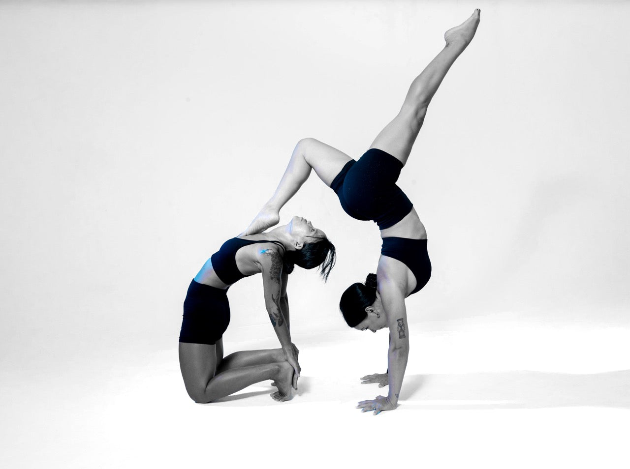 Wrong Gym Bali yoga trainers Vena and Polina performing an advanced partner acro yoga pose showcasing balance, flexibility and core strength.